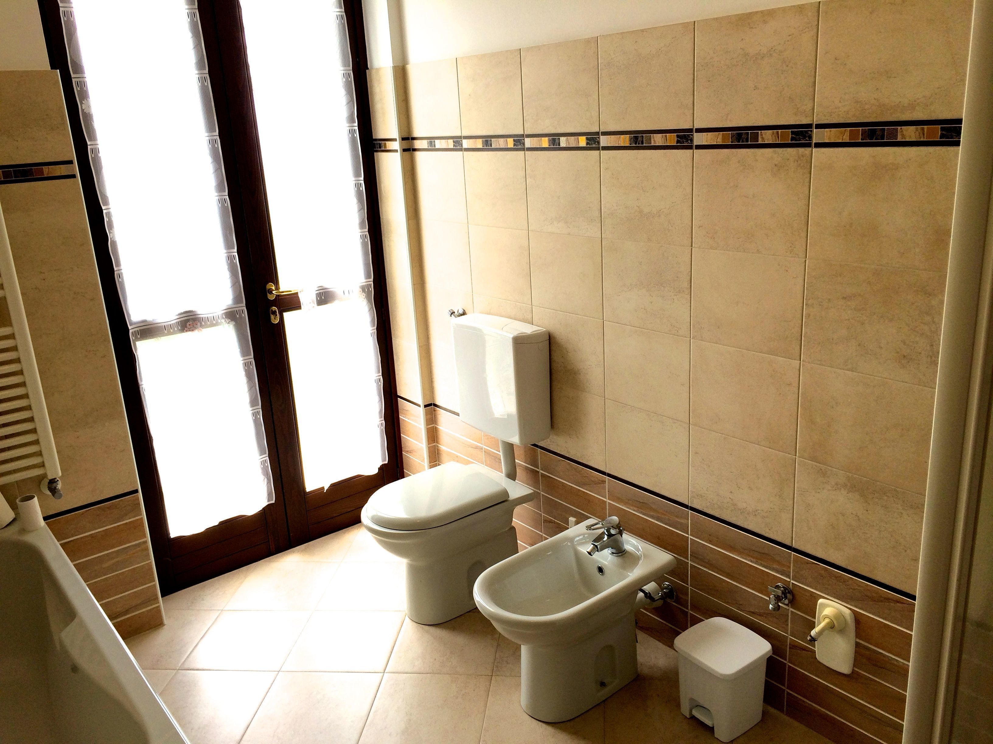 A bathroom with a toilet, bidet, and sink.