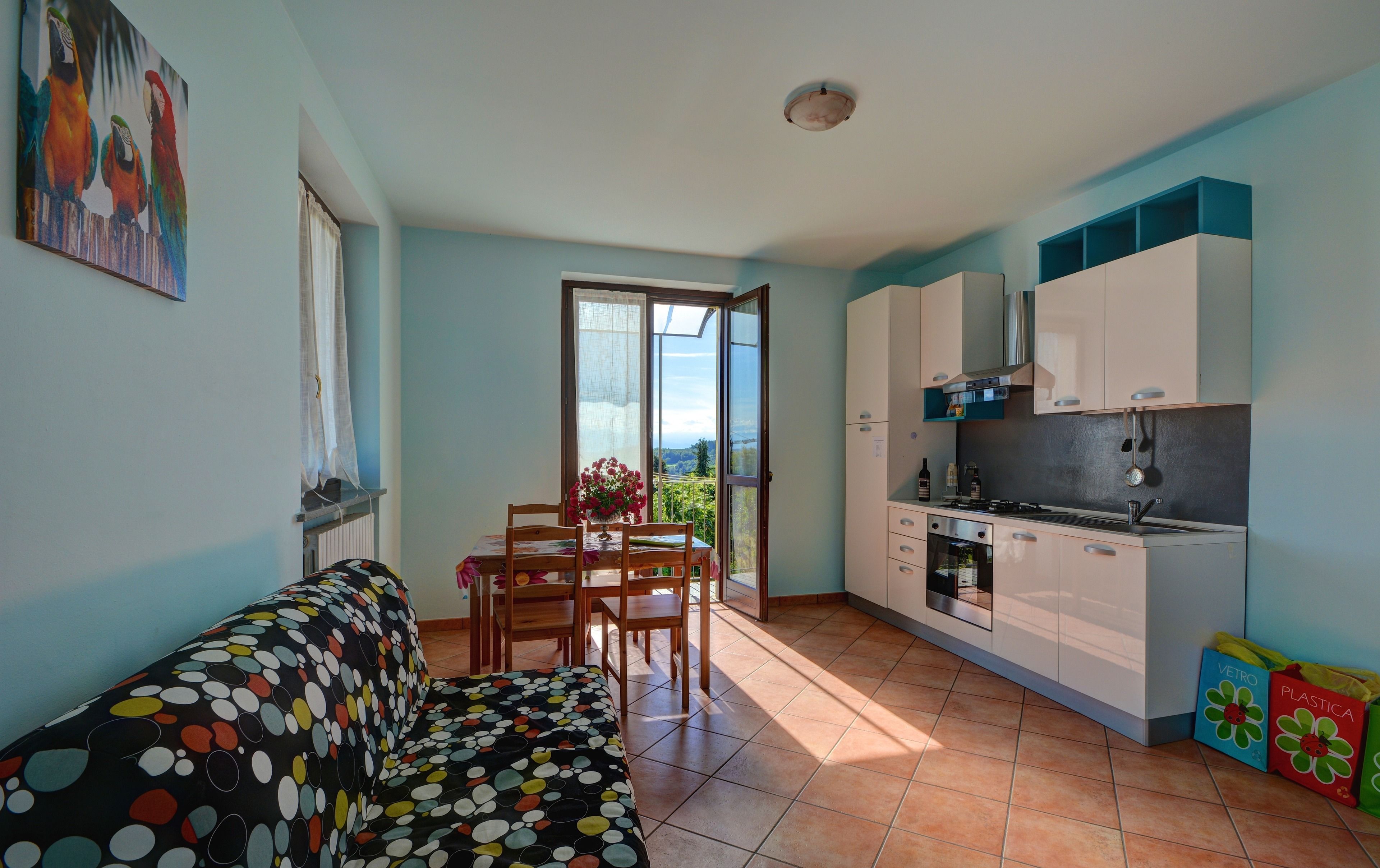 A compact living space with a dining area, kitchenette, and a sofa with a polka dot cover.