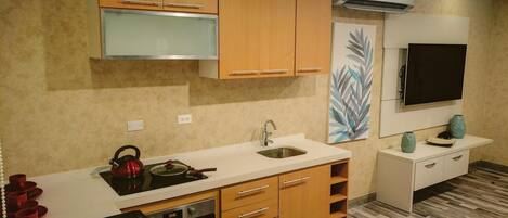 Una cocina moderna con gabinetes de madera, un lavamanos de acero inoxidable y un horno empotrado.