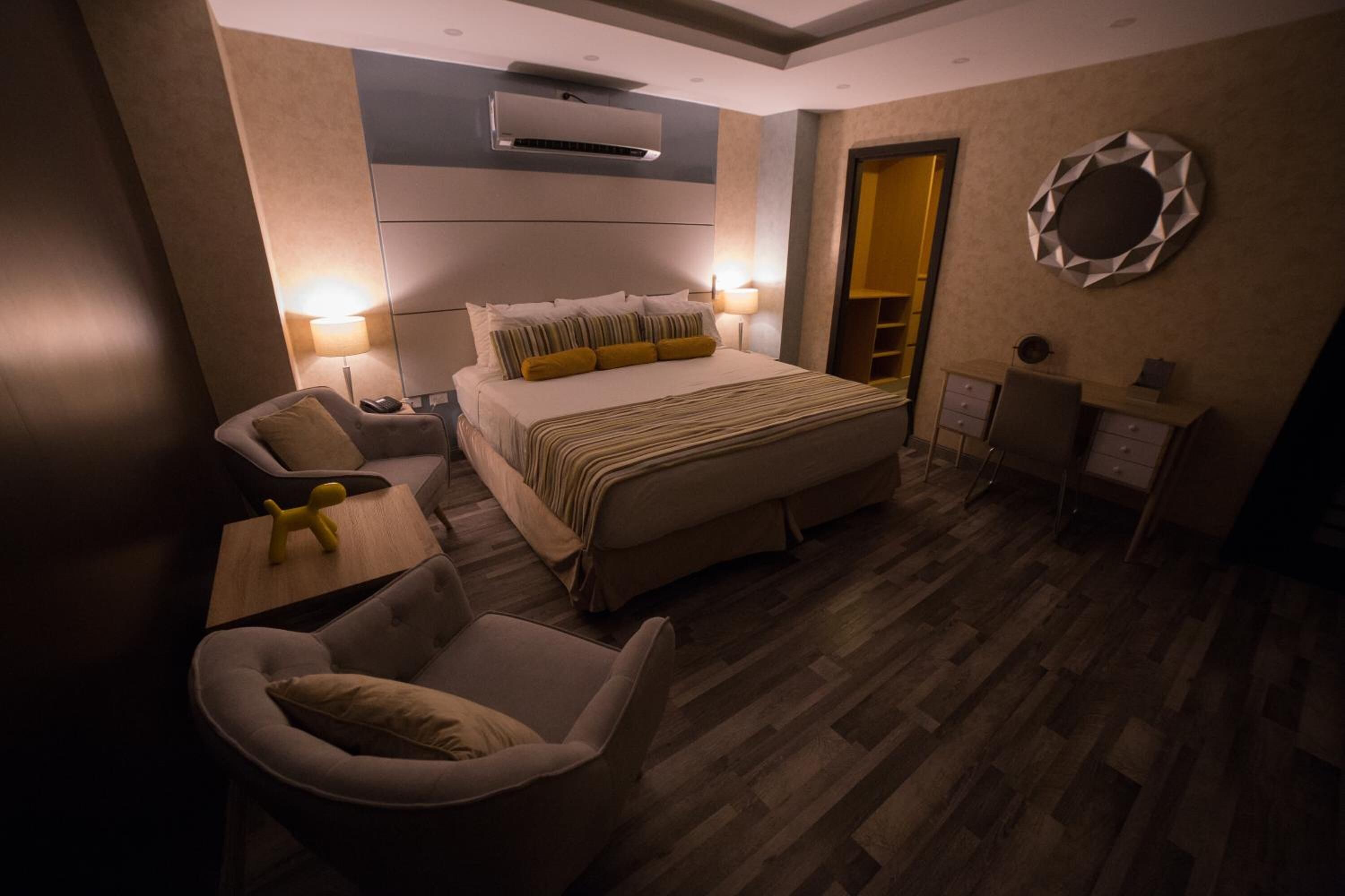 Une chambre d’hôtel moderne équipée d’un grand lit, d’un bureau, d’une chaise et d’une armoire.