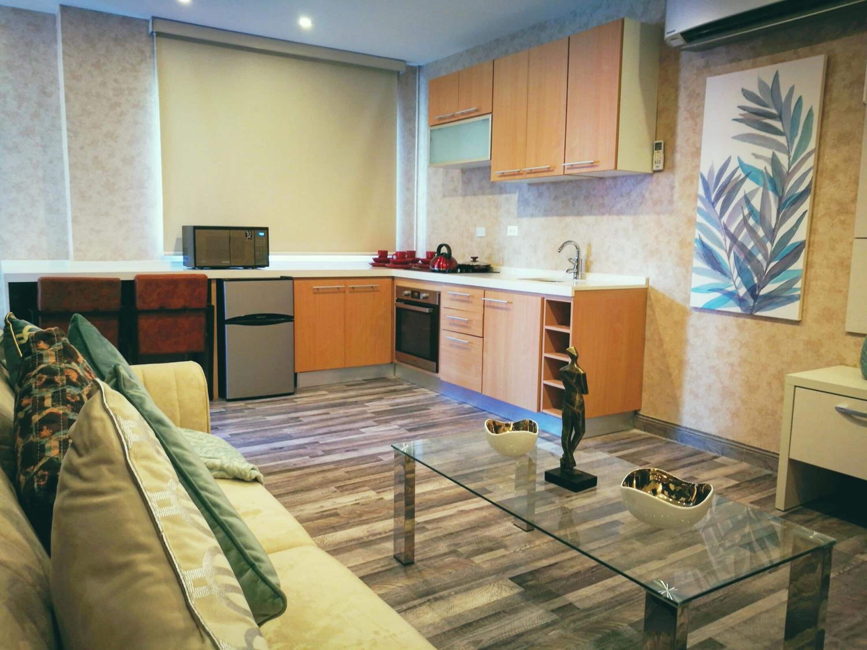 A modern kitchen with wooden cabinets, a microwave, and a sink.