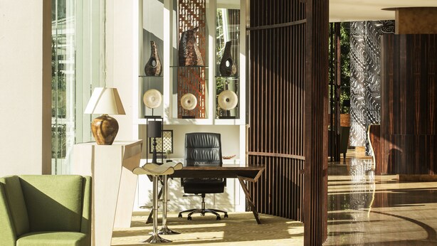 Un espacio de oficina moderno con un escritorio, una silla y objetos decorativos.