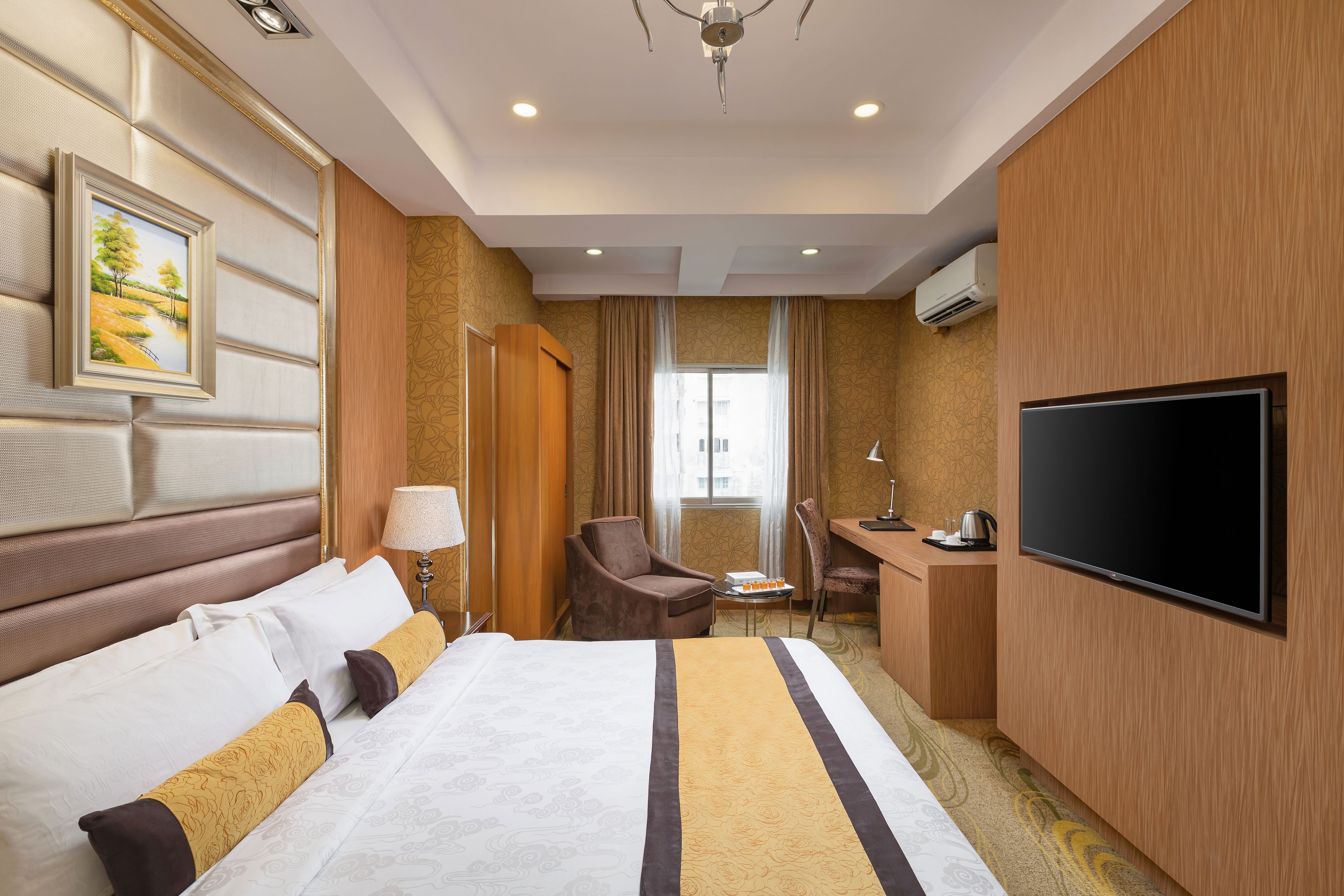 A hotel room with a bed, a desk, a television, and a window.