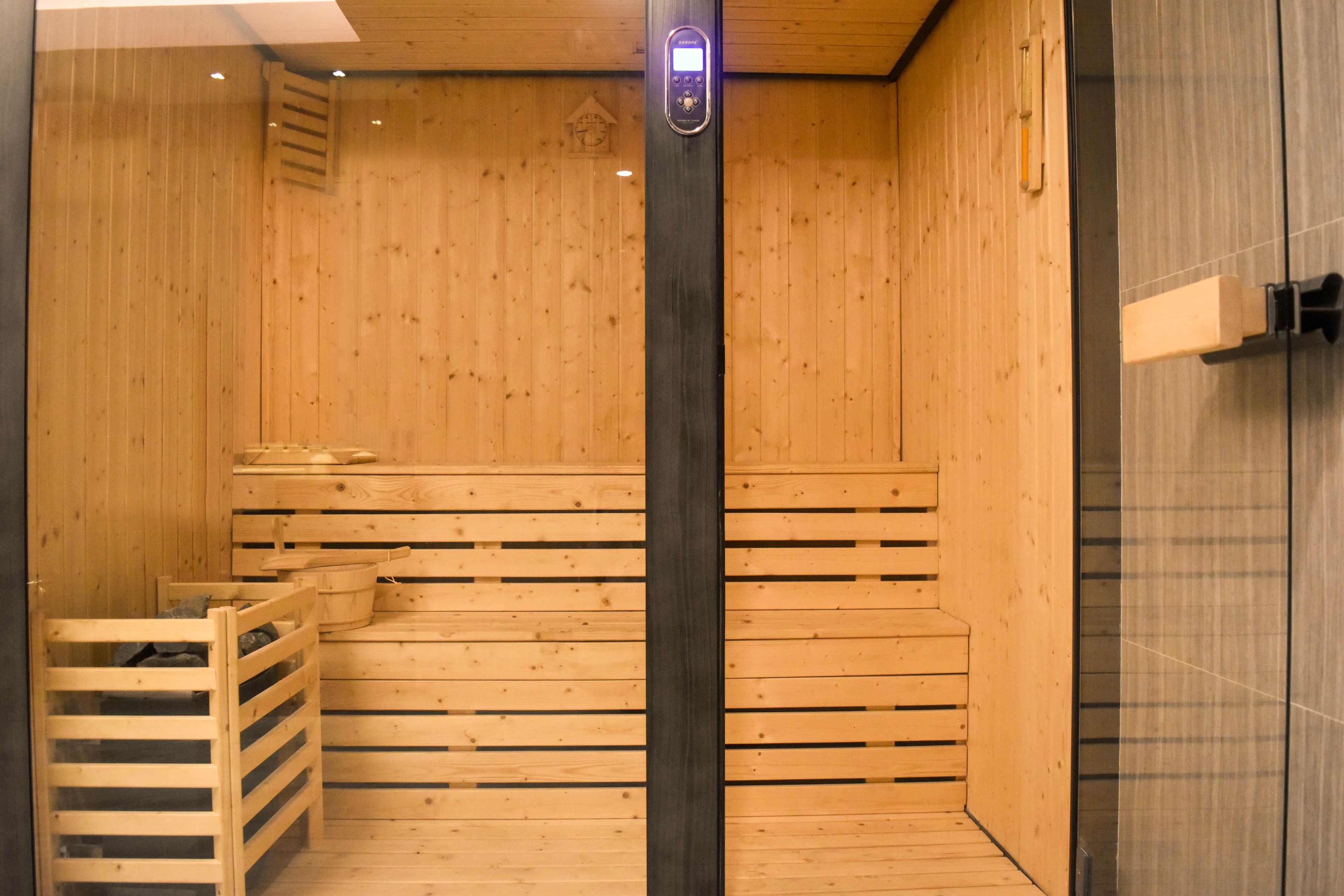 Una sauna con bancos de madera y un panel de control.
