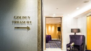 Quarto de hotel com uma placa indicando 'Golden Treasure' e uma seta indicativa.