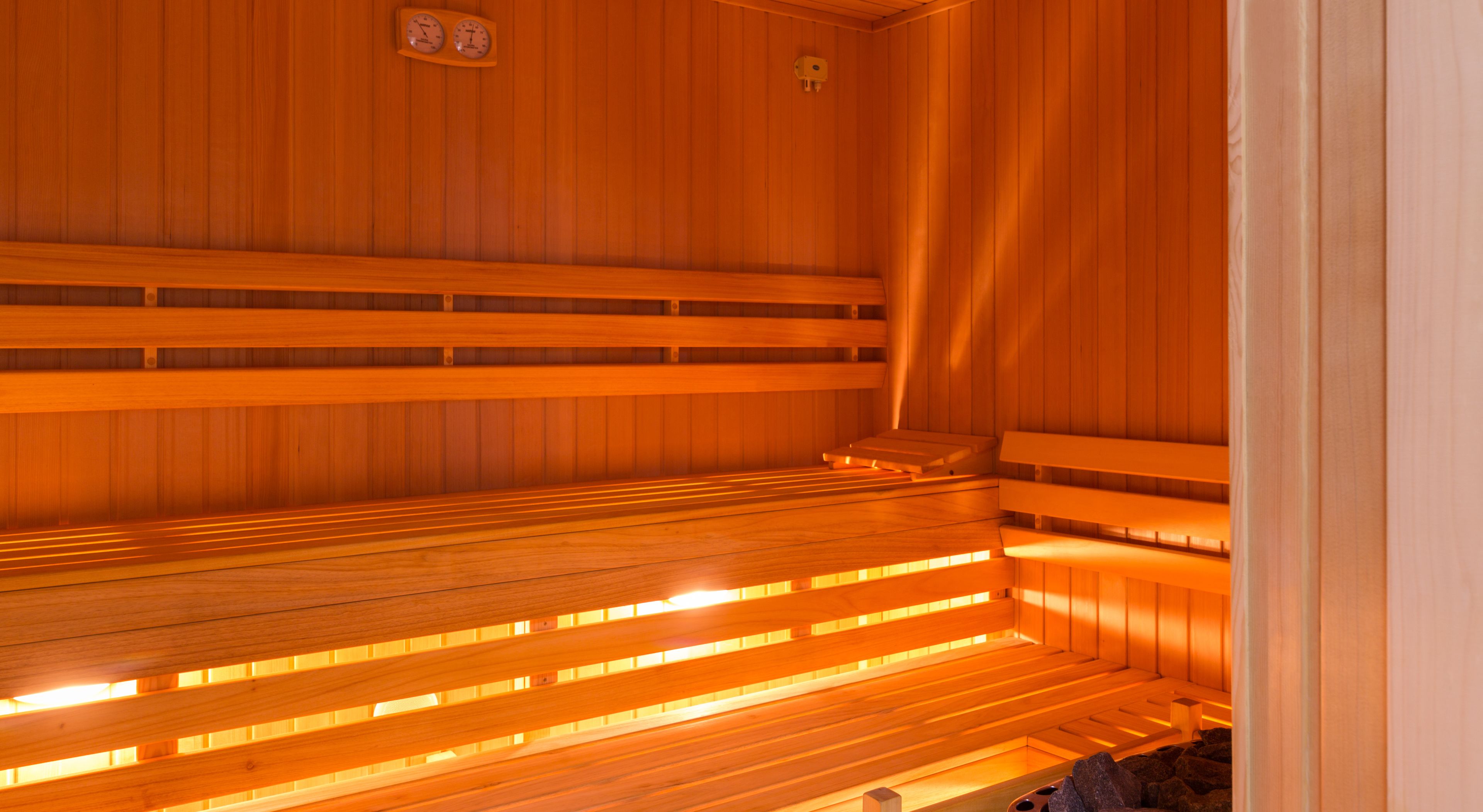 Un sauna avec des bancs en bois et un plafond incliné.
