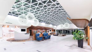 A spacious lobby with a high ceiling, modern seating, and a reception area. - DoubleTree by Hilton Krakow Hotel & Convention Center (Kraków)