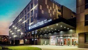 A modern hotel with a prominent "DOUBLETREE BY HILTON" sign, featuring a geometric facade and a well-lit entrance. - DoubleTree by Hilton Krakow Hotel & Convention Center (Kraków)