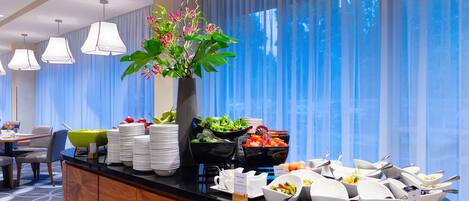 Una mesa de buffet con diversos alimentos y un centro de flores.
