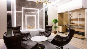 A modern meeting room with a round table, leather chairs, a large window, and a built-in sauna. - DoubleTree by Hilton Krakow Hotel & Convention Center (Kraków)