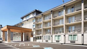 A multi-story hotel with balconies, a covered entrance, and a parking area. - Country Inn & Suites by Radisson, Gatlinburg, TN (Gatlinburg)