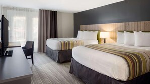 A hotel room with two beds, a desk, and a TV. - Country Inn & Suites by Radisson, Gatlinburg, TN (Gatlinburg)