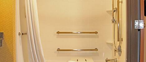A bathroom with a bathtub, a shower, and a towel rack.