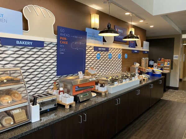 A bakery counter with a sign reading "Go ahead. Fresh Pancakes in a Minute Flat." - Holiday Inn Express & Suites Bakersfield Airport by IHG (Bakersfield)