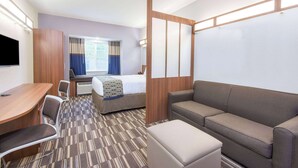 A hotel room with a bed, a sofa, a desk, and a TV. - Microtel Inn & Suites By Wyndham Cadiz (Cadiz)