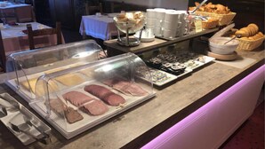Un bufé de desayuno con diversas opciones de comida y una estación de café.