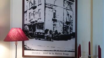 Une photographie en noir et blanc, encadrée, représentant un bâtiment sur lequel on peut lire l’inscription « Diekirch - Hôtel de la Maison Rouge ».
