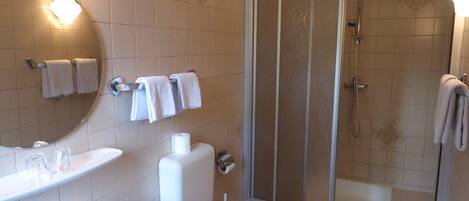 A bathroom with a sink, toilet, and shower.