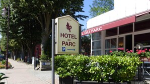 Señal del Hotel du Parc con un símbolo de estacionamiento, que indica un área de estacionamiento cerca.