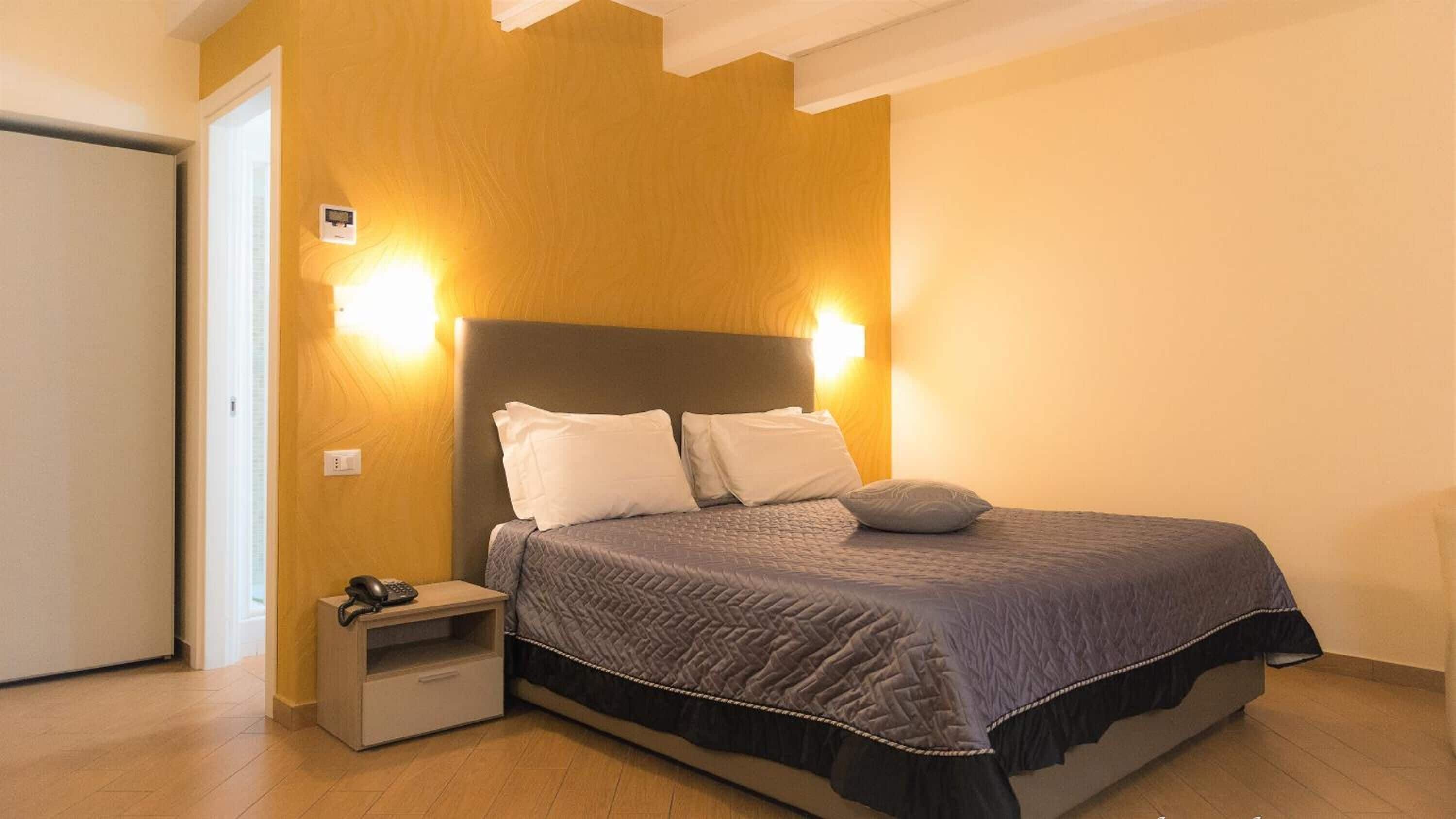 A bedroom with a bed, bedside table, and nightstand.