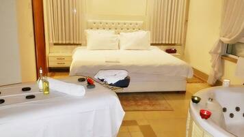 Una habitación de hotel con una cama, una camilla de masaje y una bañera.