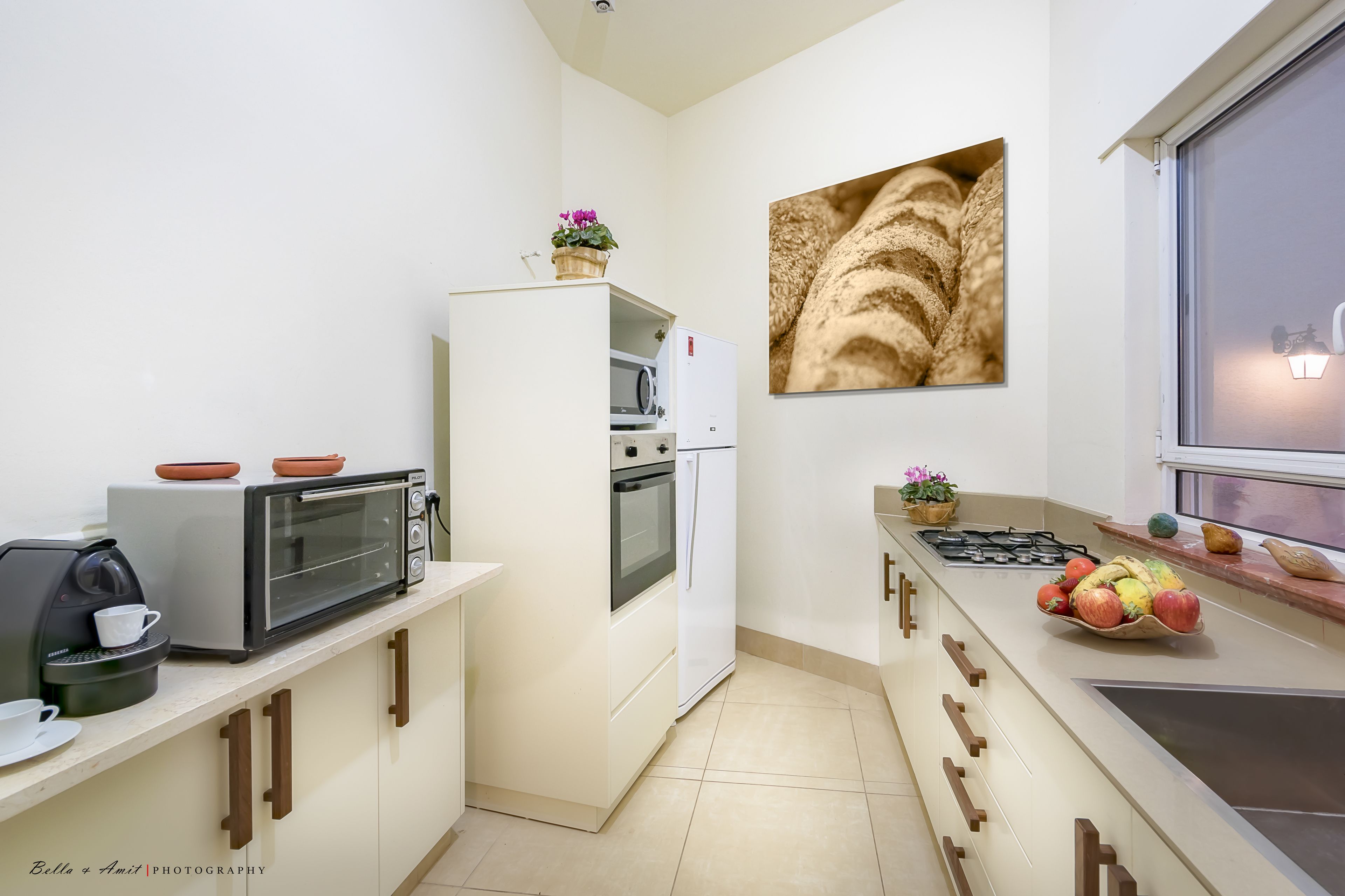 Eine moderne Küche mit Mikrowelle, Toaster, Backofen und Spüle.