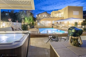 A pool area with hot tubs, outdoor seating, and a staircase leading to a second floor. - Villar (Rosh Pinna)