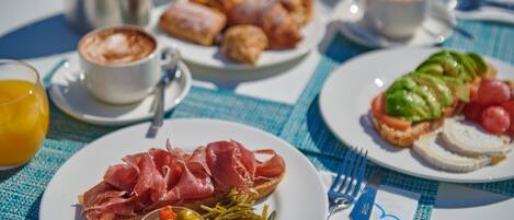 A breakfast setting with plates of food, a coffee cup, and a juice glass.