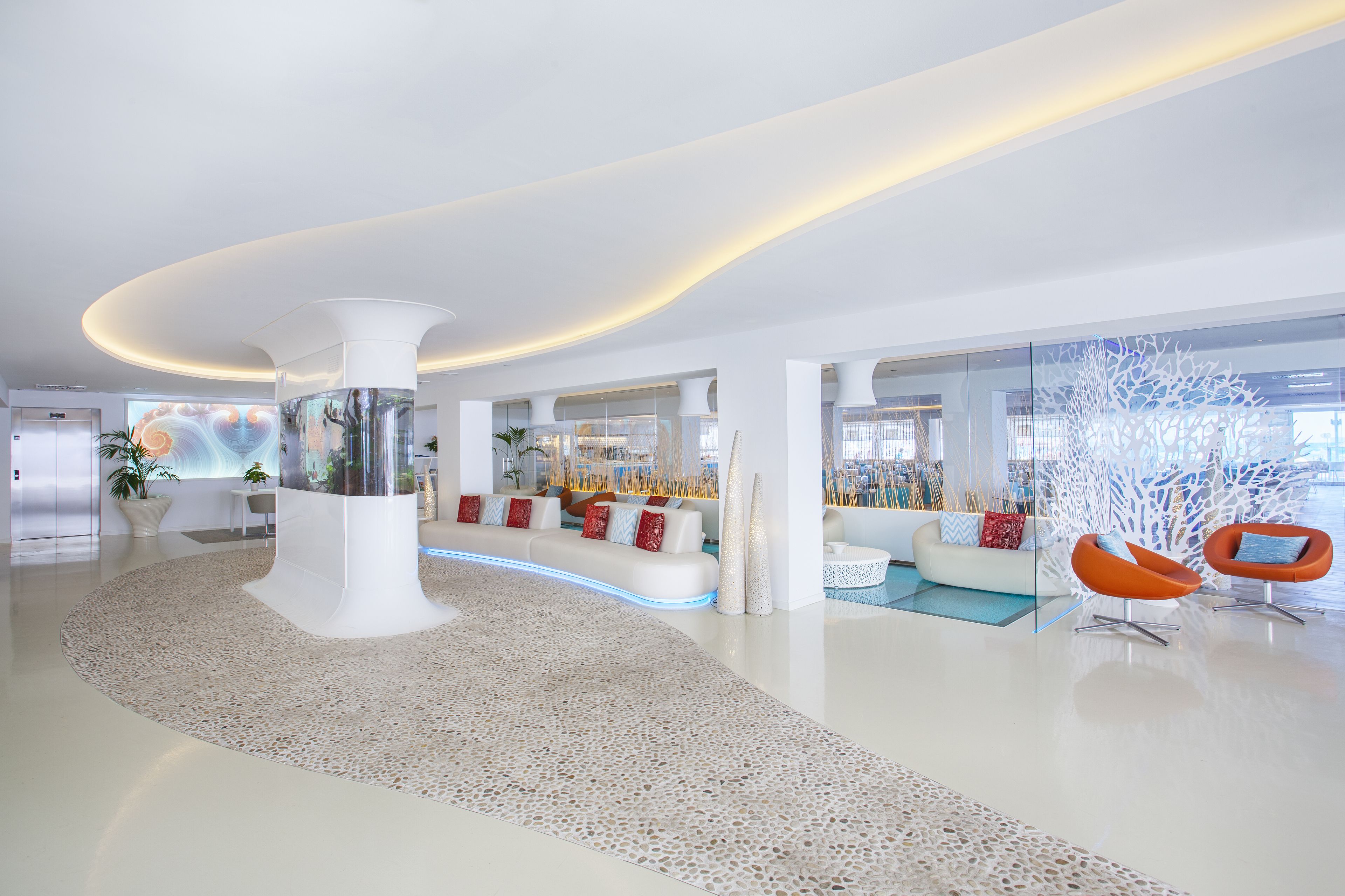 Un hall d’entrée moderne avec une colonne centrale, des espaces de détente et une cloison en verre.