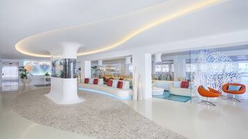 Un hall d’entrée moderne avec une colonne centrale, des espaces de détente et une cloison en verre.