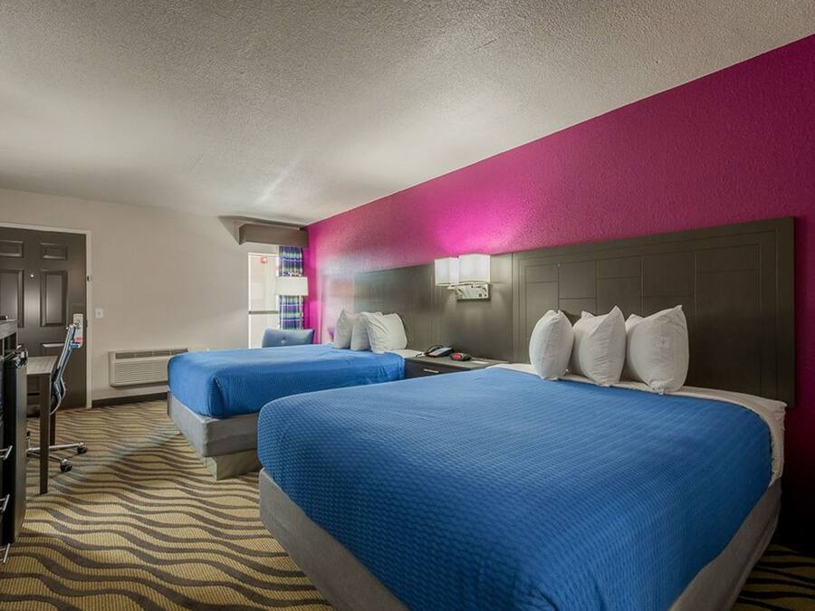 Una habitación de hotel con dos camas, un escritorio y un minibar.