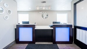 A reception area with two reception desks, a clock, and a ceiling light fixture. - Stratford House Inns - Edmond (Edmond)