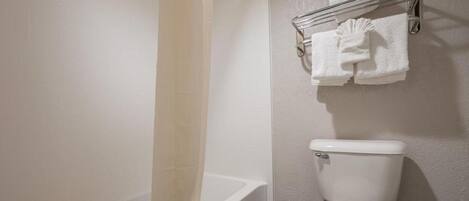 Une salle de bain équipée d’une baignoire, de toilettes et d’un porte-serviettes avec des serviettes.