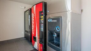 A vending machine with a Coca-Cola logo and an ice dispenser. - Stratford House Inns - Edmond (Edmond)