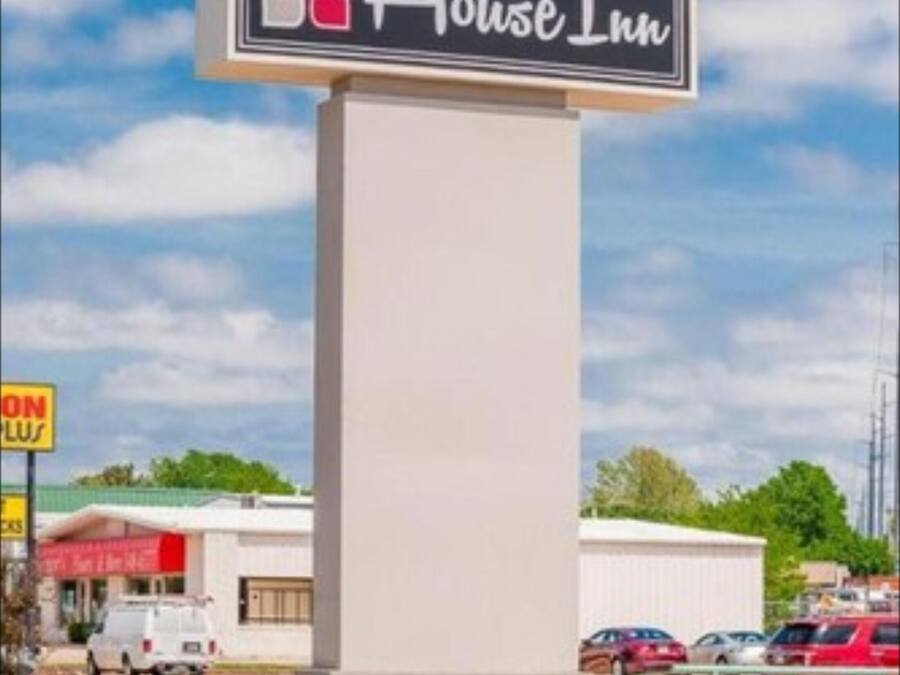 A hotel sign with a name and a colorful logo.