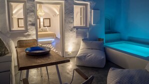 Un interior moderno con comedor, una zona de estar acogedora y una bañera grande iluminada.