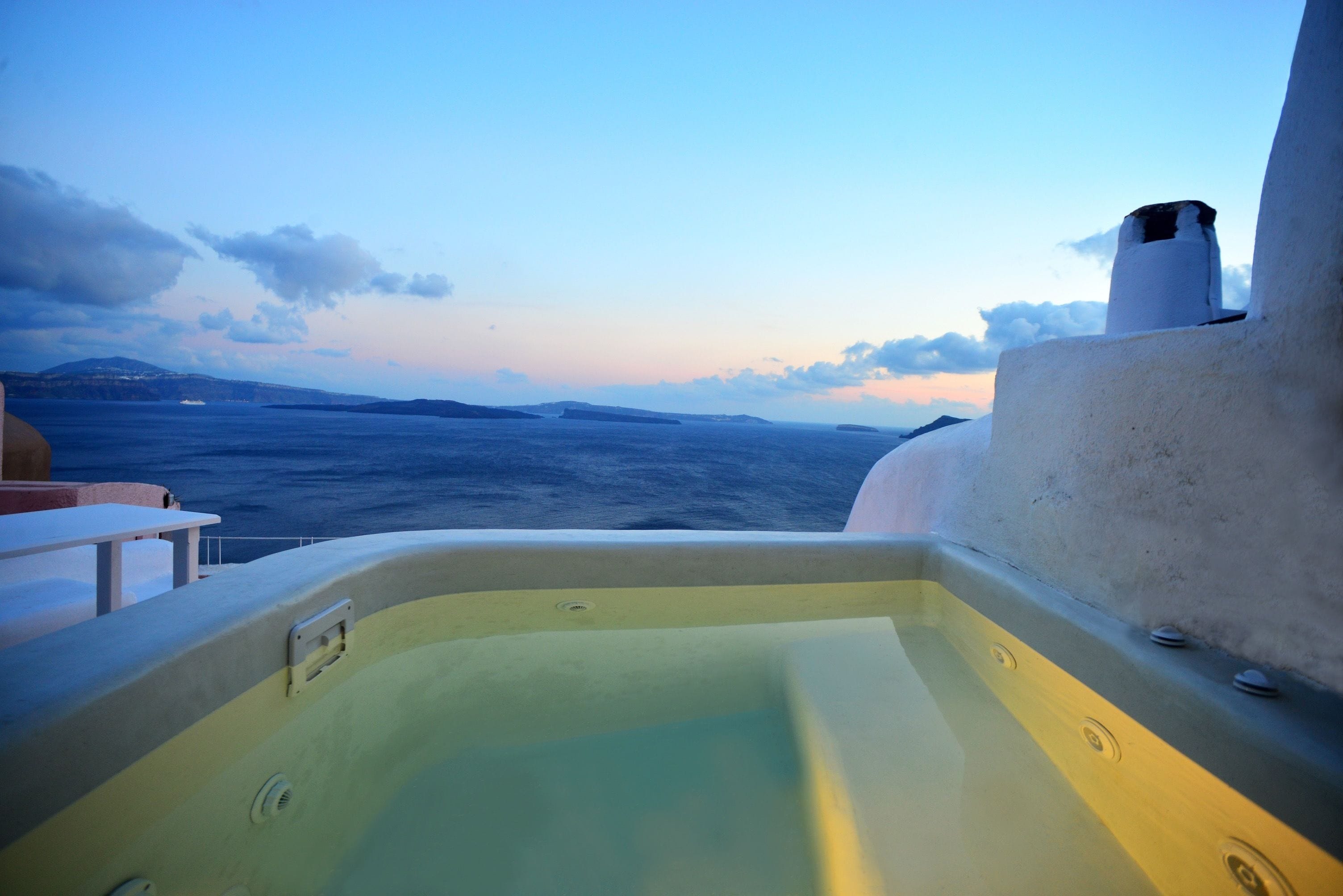 A hot tub with a view of the sea and distant islands.