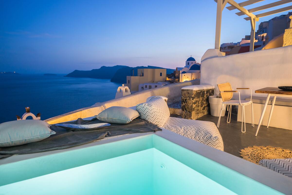 Terraza en la azotea con vistas al mar, que incluye un espacio de descanso con cojines y una mesa.