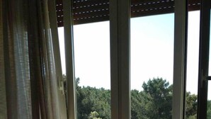 A room with a table and chairs, large windows with a view of trees and a road. - Hotel Brasilia (Pietrasanta)