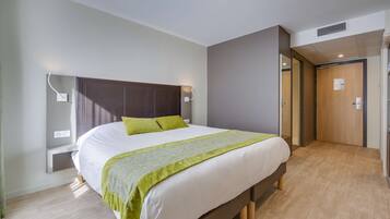 A modern bedroom with a large bed, bedside tables, and a walk-in closet.