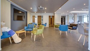 A modern waiting area with multiple seating options, including sofas and chairs, and a reception desk.