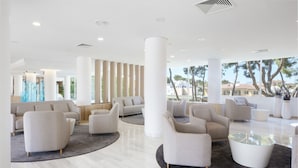 Een ruime lobby met modern meubilair, grote ramen en uitzicht op de omgeving.