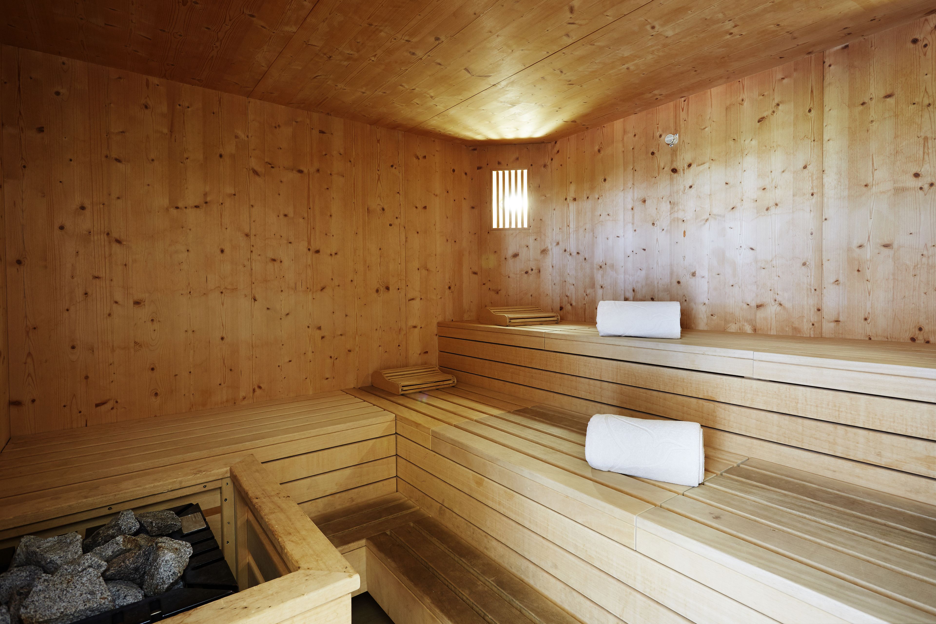 A wooden sauna with benches and a stone basin.