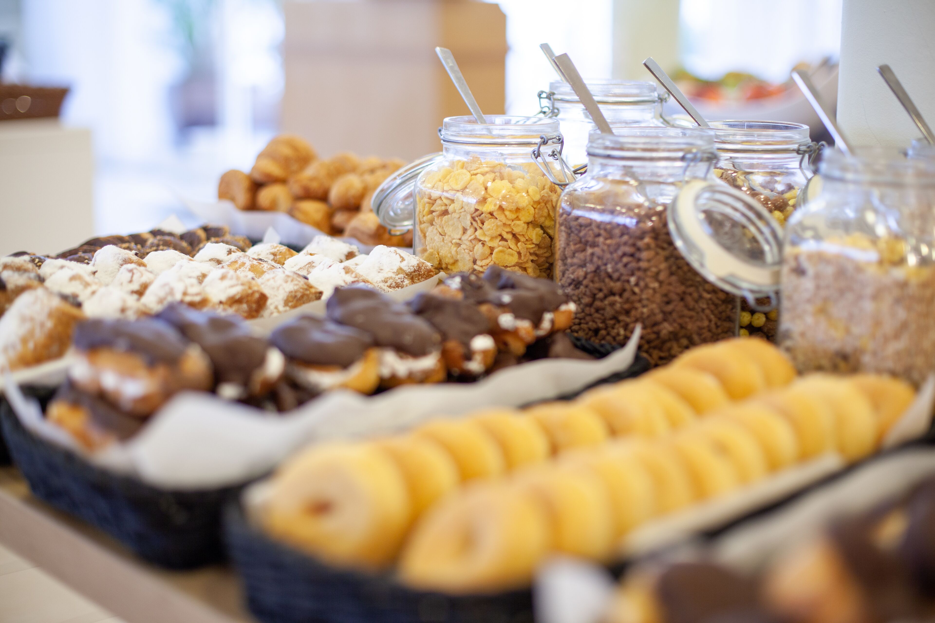 Een buffet met diverse soorten eten, zoals gebak, ontbijtgranen en chocolade lekkernijen.