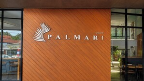 A wooden wall with the text 'PALMARI' and a palm leaf logo. - Palmari Boutique Hotel (Nuea Khlong)