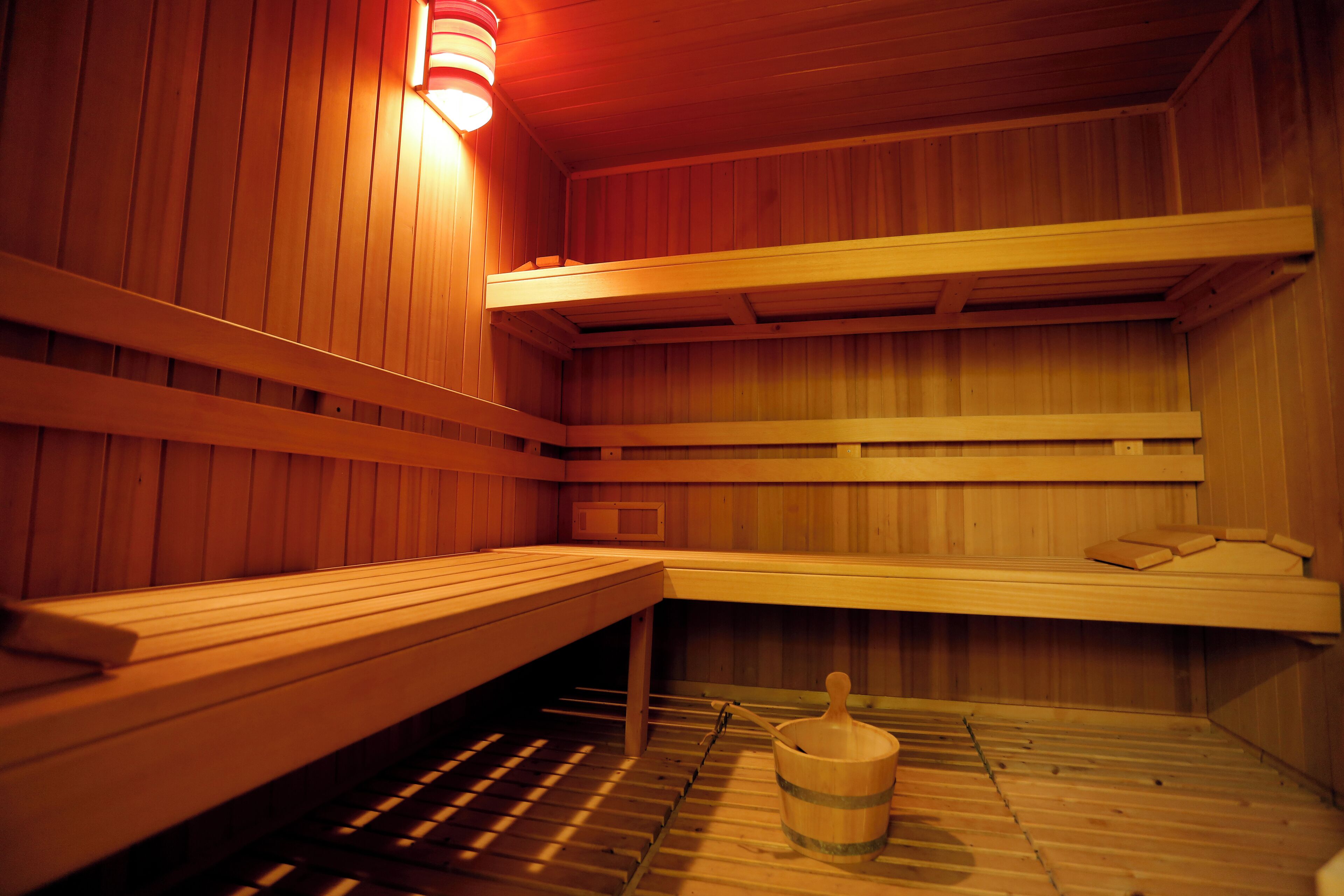 En sauna med træbænke og en spand.