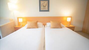 A double bed with two bedside tables, each with a lamp. A framed picture hangs on the wall above the bed.