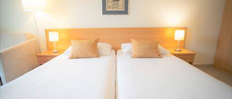 A double bed with two bedside tables, each with a lamp. A framed picture hangs on the wall above the bed.