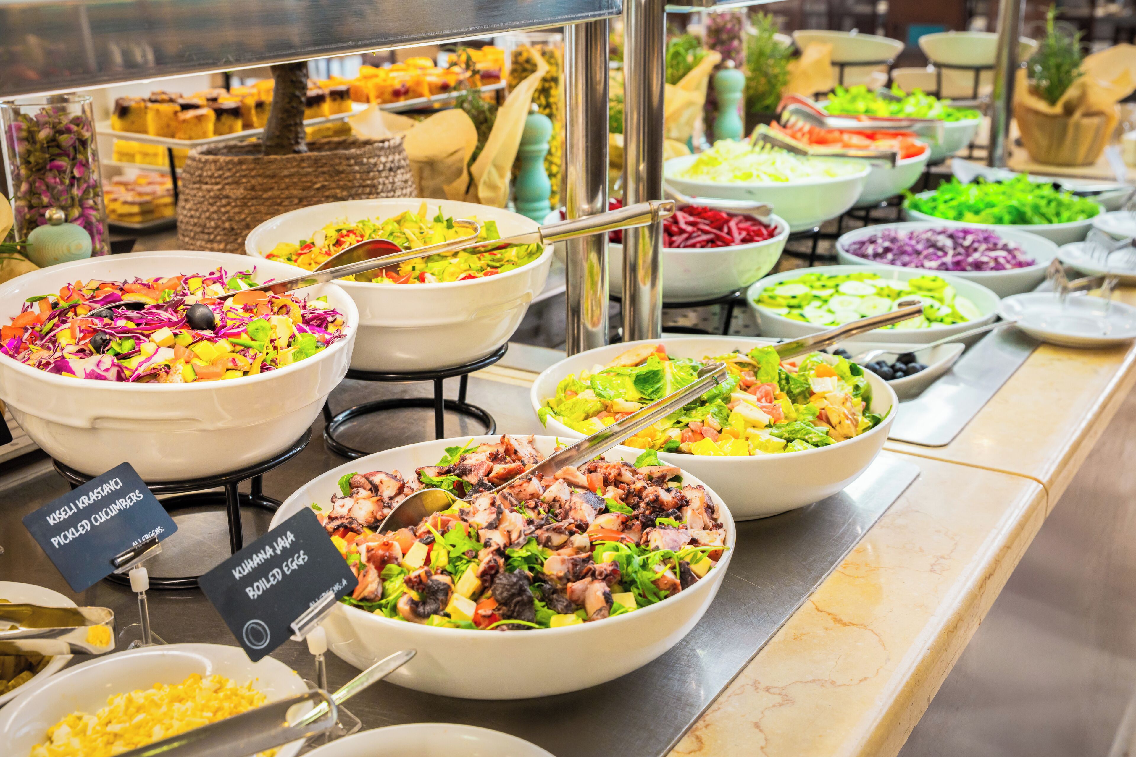 A buffet with various dishes including salads, vegetables, and meats.