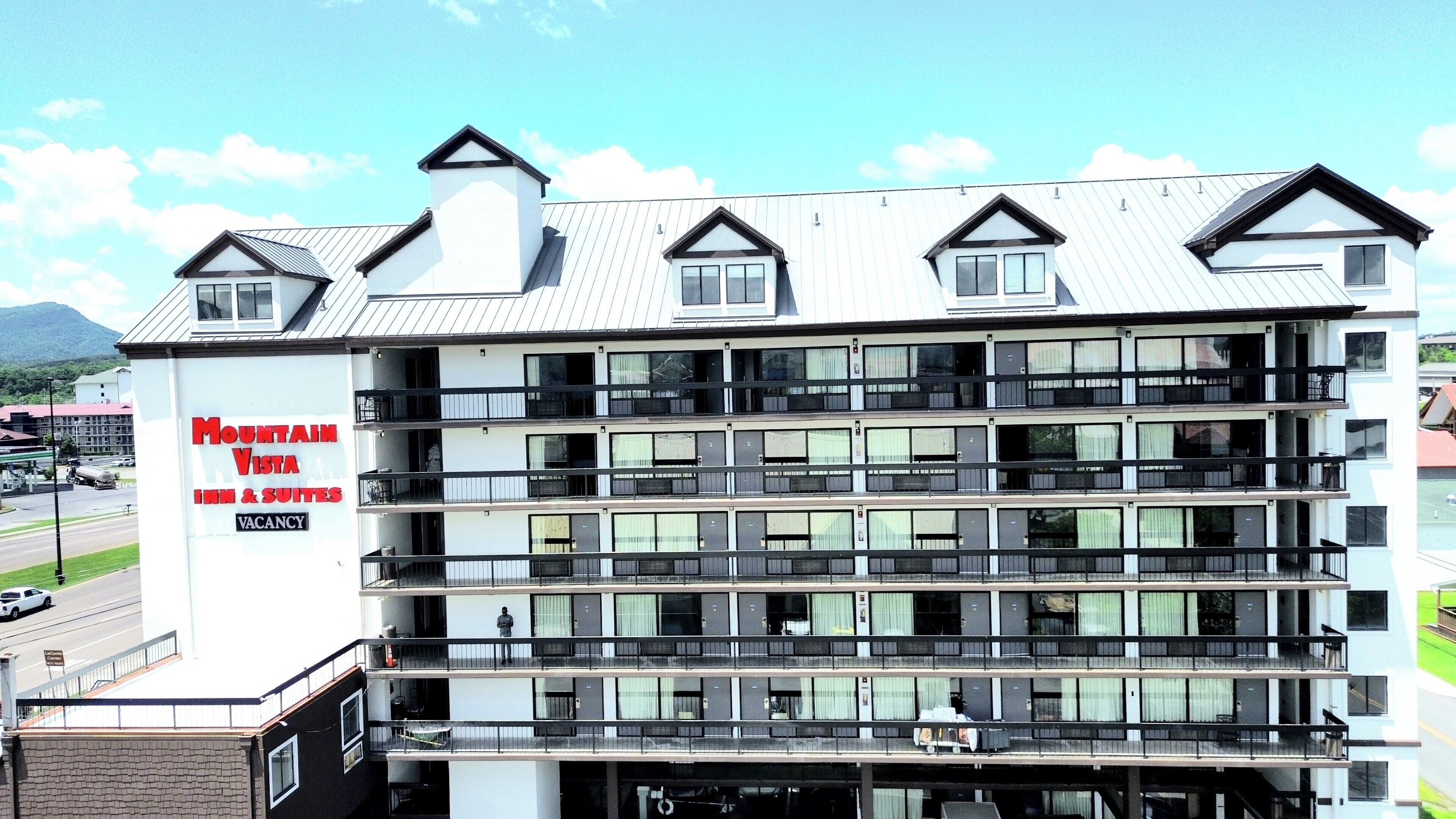 A multi-story hotel with a sign advertising "Mountain Vista Inn & Suites" and a vacancy.